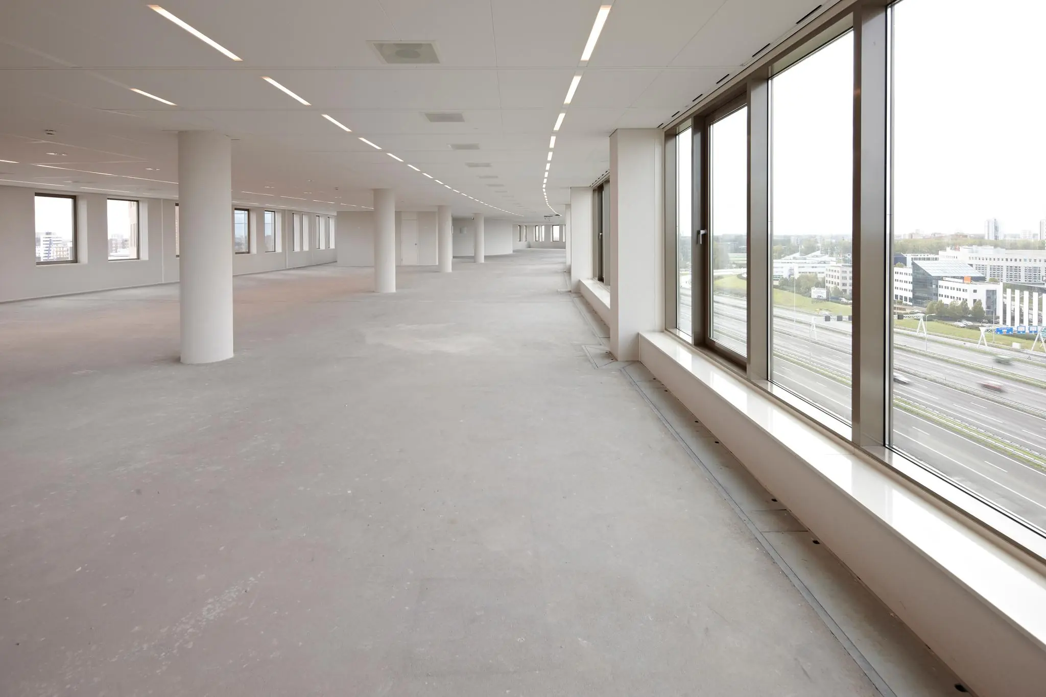 Leeg, modern kantoorpand aan de Fascinatio Boulevard met grote ramen en uitzicht op de snelweg.